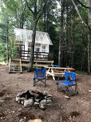 two chairs and a fire pit in front of a cabin at Romantic New York Getaway near the Adirondacks in Cambridge