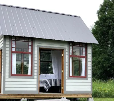 a tiny house with a gray roof and windows at Runamuk Farm Camp with a View near the Adirondacks in Cambridge