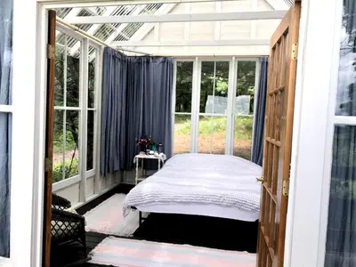 a bedroom with a bed in a glass house at Runamuk Farm Camp Tiny House near Cambridge, New York in Cambridge