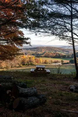 a picnic table sitting in the middle of a field at Runamuk Farm Camp Tiny House near Cambridge, New York in Cambridge