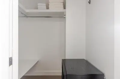 a room with a closet with a table and towels at Blueground Bloomingdale fitness center nr Central Park NYC-1869 in New York