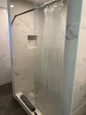 a shower with a glass door in a bathroom at Overlook Hotel in Saugerties
