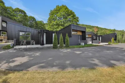 a black house with a driveway in front of it at Overlook Hotel in Saugerties