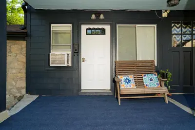 a wooden bench sitting on the front porch of a house at Croton Nook - Cozy Getaway in Croton-on-Hudson