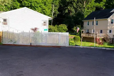 a white fence in front of a house at Croton Nook - Cozy Getaway in Croton-on-Hudson