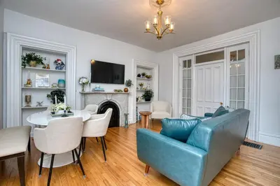 a living room with a blue couch and a table at Luxury Downtown w Backyard in Troy