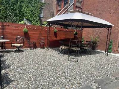 a patio with a table and chairs under an umbrella at Luxury Downtown w Backyard in Troy