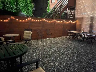 a patio with tables and chairs and lights at Luxury Downtown w Backyard in Troy
