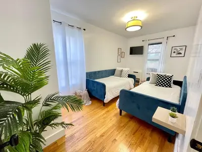 a living room with two beds and a blue couch at Madison Ave Oasis in New York