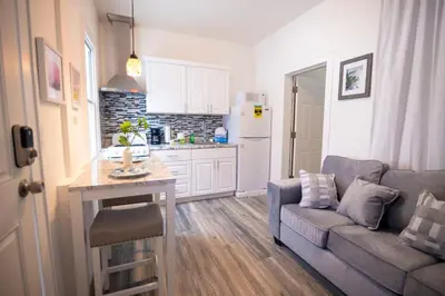 a living room with a couch and a kitchen at Lovely 1 bedroom apt with patio by Yankee Stadium in Melrose