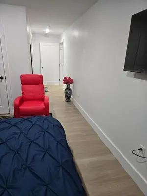 a room with a red chair and a vase of flowers at Tkc Villa in Newark