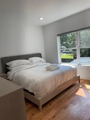 a white bedroom with a bed and a window at Elegant Retreat Near EWR n NYC in Newark