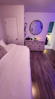 a bedroom with a white bed and a mirror at The Eternal Oasis in Newark
