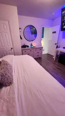 a bedroom with a large white bed and a mirror at The Eternal Oasis in Newark