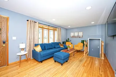 a living room with a blue couch and a table at Five-bedroom home in Schenectady