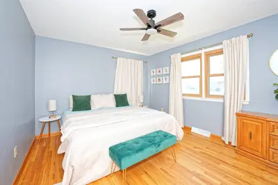 a bedroom with a bed and a ceiling fan at Five-bedroom home in Schenectady