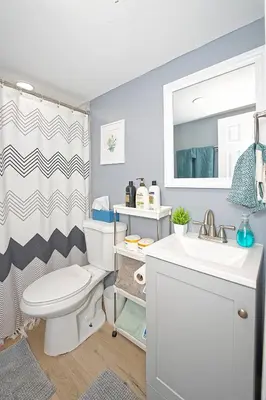 a bathroom with a toilet and a sink and a shower at Five-bedroom home in Schenectady