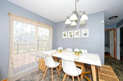 a dining room with a white table and chairs at Five-bedroom home in Schenectady