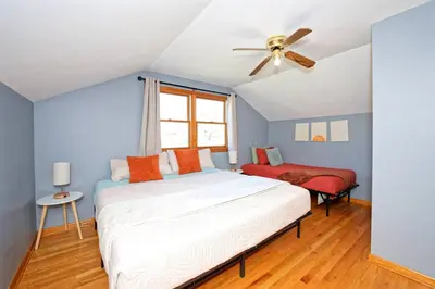 a bedroom with a bed and a ceiling fan at Five-bedroom home in Schenectady