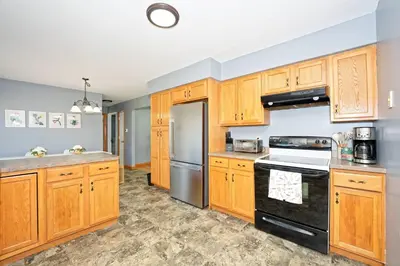 a kitchen with wooden cabinets and a black stove top oven at Five-bedroom home in Schenectady