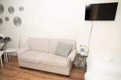 a white couch in a living room with a tv at East Village Center Apartment7 w Full Amenities Great New York Location in New York