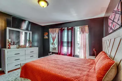 a bedroom with a bed and a dresser and windows at 3 Mi to Dtwn Newark Eclectic and Walkable Apt! in Newark