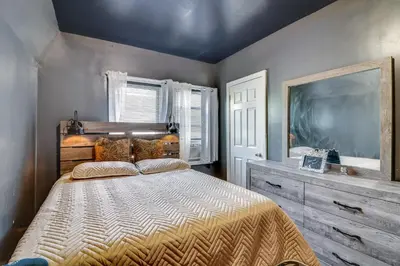 a bedroom with a large bed and a large tv at 3 Mi to Dtwn Newark Eclectic and Walkable Apt! in Newark