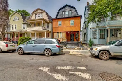 two cars parked in front of a row of houses at 3 Mi to Dtwn Newark Eclectic and Walkable Apt! in Newark