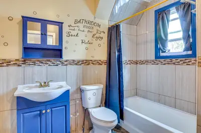 a bathroom with a toilet and a sink and a tub at 3 Mi to Dtwn Newark Eclectic and Walkable Apt! in Newark