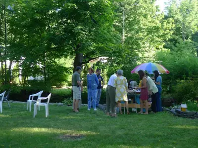 a group of people standing around a table in a yard at Morning Glory B n B Woodstock NY in Woodstock