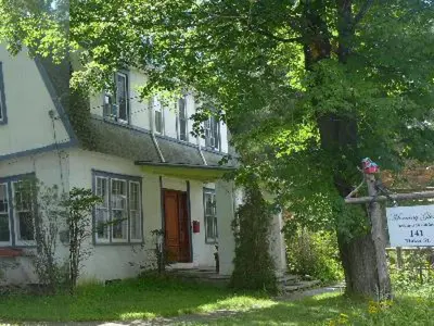 a white house with a tree in front of it at Morning Glory B n B Woodstock NY in Woodstock