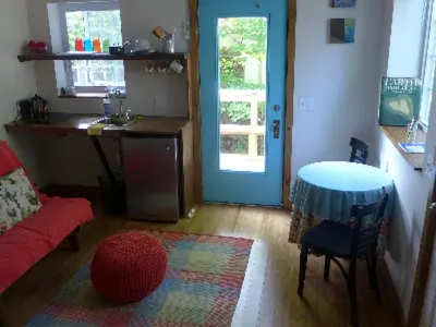 a living room with a table and a kitchen at Morning Glory B n B Woodstock NY in Woodstock