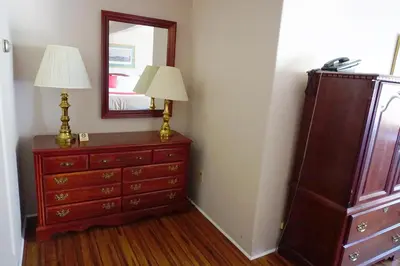 a dresser with a mirror and a lamp on it at Stay Saratoga in Saratoga Springs