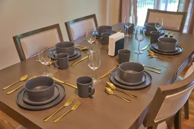 a wooden table with plates and wine glasses on it at Cozy Huguenot Hideaway in Huguenot