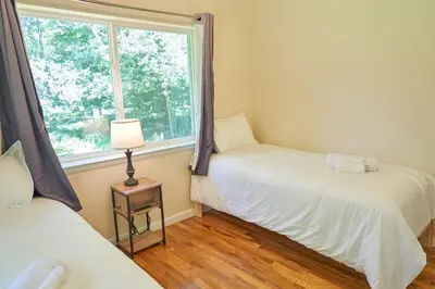 two beds in a room with a window at Cozy Huguenot Hideaway in Huguenot