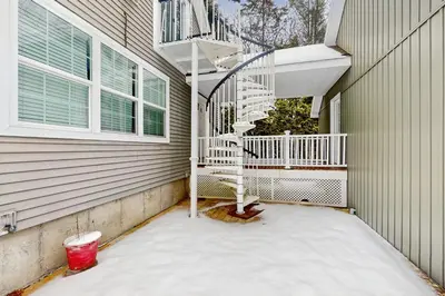 a snow covered porch with a spiral staircase on a house at Stargazing Daydreamer in Arlington