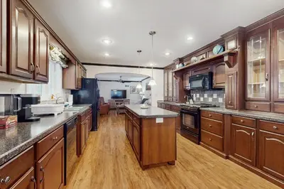a large kitchen with wooden cabinets and wooden floors at Stargazing Daydreamer in Arlington