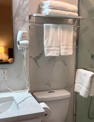 a bathroom with a toilet and a sink and towels at Flushing City Escape in Flushing