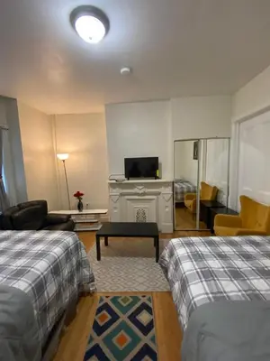 a hotel room with two beds and a television at C Jay Homes 6 minutes Walk to Journal square in Jersey City