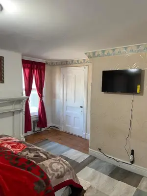 a bedroom with a bed and a flat screen tv on the wall at C Jay Homes 6 minutes Walk to Journal square in Jersey City