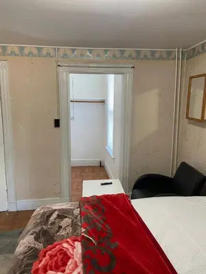a bedroom with a bed and a chair and a window at C Jay Homes 6 minutes Walk to Journal square in Jersey City