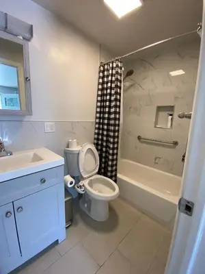 a bathroom with a toilet and a sink and a tub at C Jay Homes 6 minutes Walk to Journal square in Jersey City
