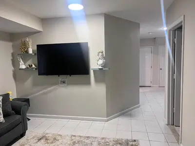 a living room with a flat screen tv on a wall at Haven 2 Bedroom by EWR airport in Newark