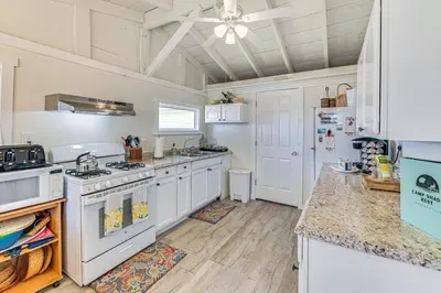 a kitchen with white appliances and a ceiling fan at Private Dock Lakefront Gem on Saratoga Lake in Saratoga Springs