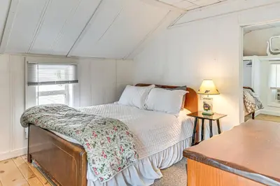 a small bedroom with a bed and a table at Private Dock Lakefront Gem on Saratoga Lake in Saratoga Springs