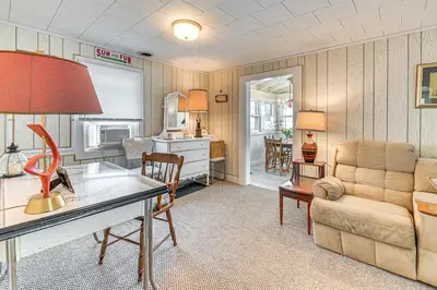 a living room with a desk and a couch at Private Dock Lakefront Gem on Saratoga Lake in Saratoga Springs