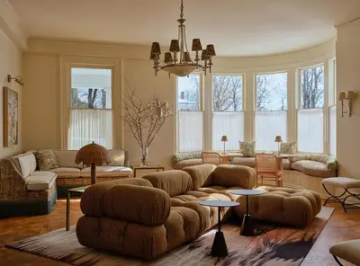 a living room with couches and tables and windows at Belden House & Mews in Litchfield