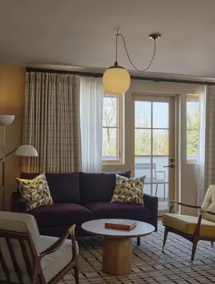 a living room with a blue couch and a table at Belden House & Mews in Litchfield