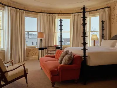 a bedroom with a bed and a chair and a couch at Belden House & Mews in Litchfield
