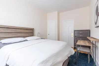 a bedroom with a large white bed and a desk at 5 Bedroom 2 Bath Full Floor Midtown in New York